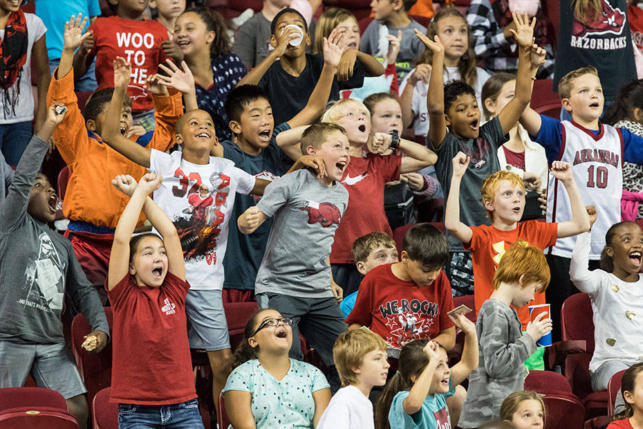 A packed crowd of kids cheering at a youth sports game